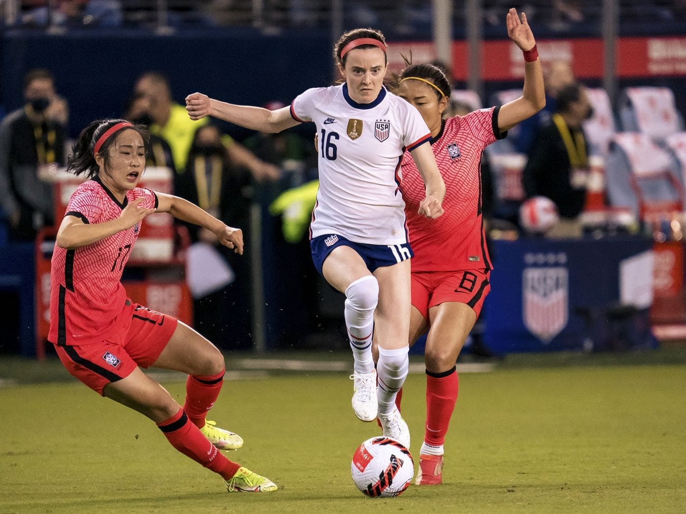 Rose Lavelle dribbling through two South Korean defenders. Photo by Kyle Rivas/Getty Images