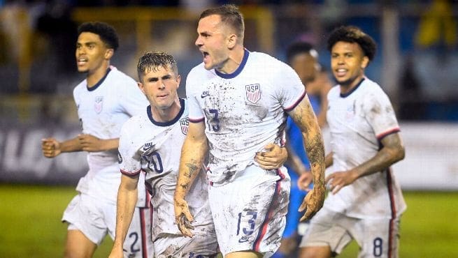 USMNT players Jordan Morris, Christian Pulisic, and Tyler Adams celebrate equalizing goal against El Salvador in CONCACAF Nations League match June 2022.