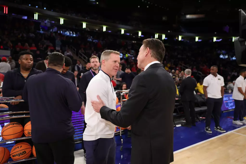 St. John's head coach Rick Pitino and Michigan head coach Dusty May embrace and shake hands at center court before tip-off at Madison Square Garden on October 25, 2025