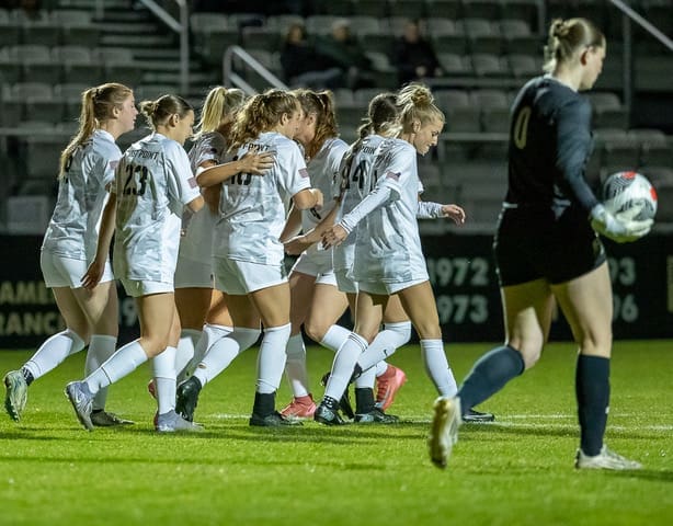 Army West Point women's soccer players embrace in team celebration after Sophia Henry's goal against Loyola at Clinton Field on October 24, 2025