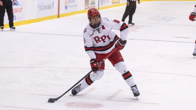 RPI defenseman Kazimier Sobieski cuts through the left circle on his skates, loading up a wrist shot with his hockey stick on the ice.