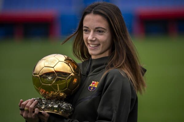 Aitana Bonmatà holds her Ballon d'Or Féminin trophy while wearing Barcelona training kit at team facility