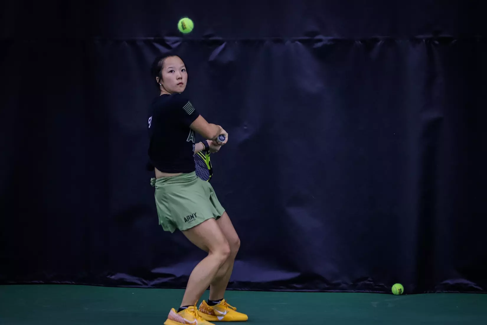 Army women’s tennis player Ylan Duong tracks the ball and prepares a two-handed backhand during a match.