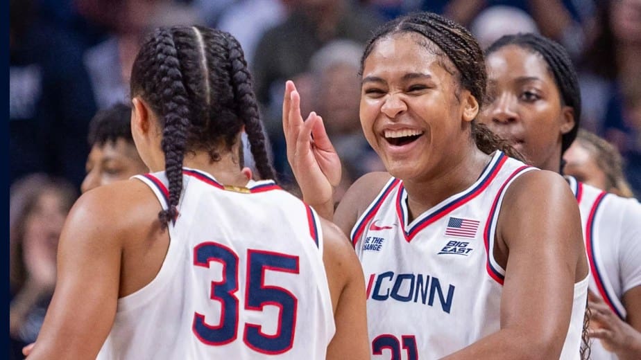 UConn women’s basketball players Sarah Strong (#21) and Azzi Fudd (#35) share a celebratory moment on the court, smiling and high-fiving during a game. Mandatory Credit: UConn Athletics