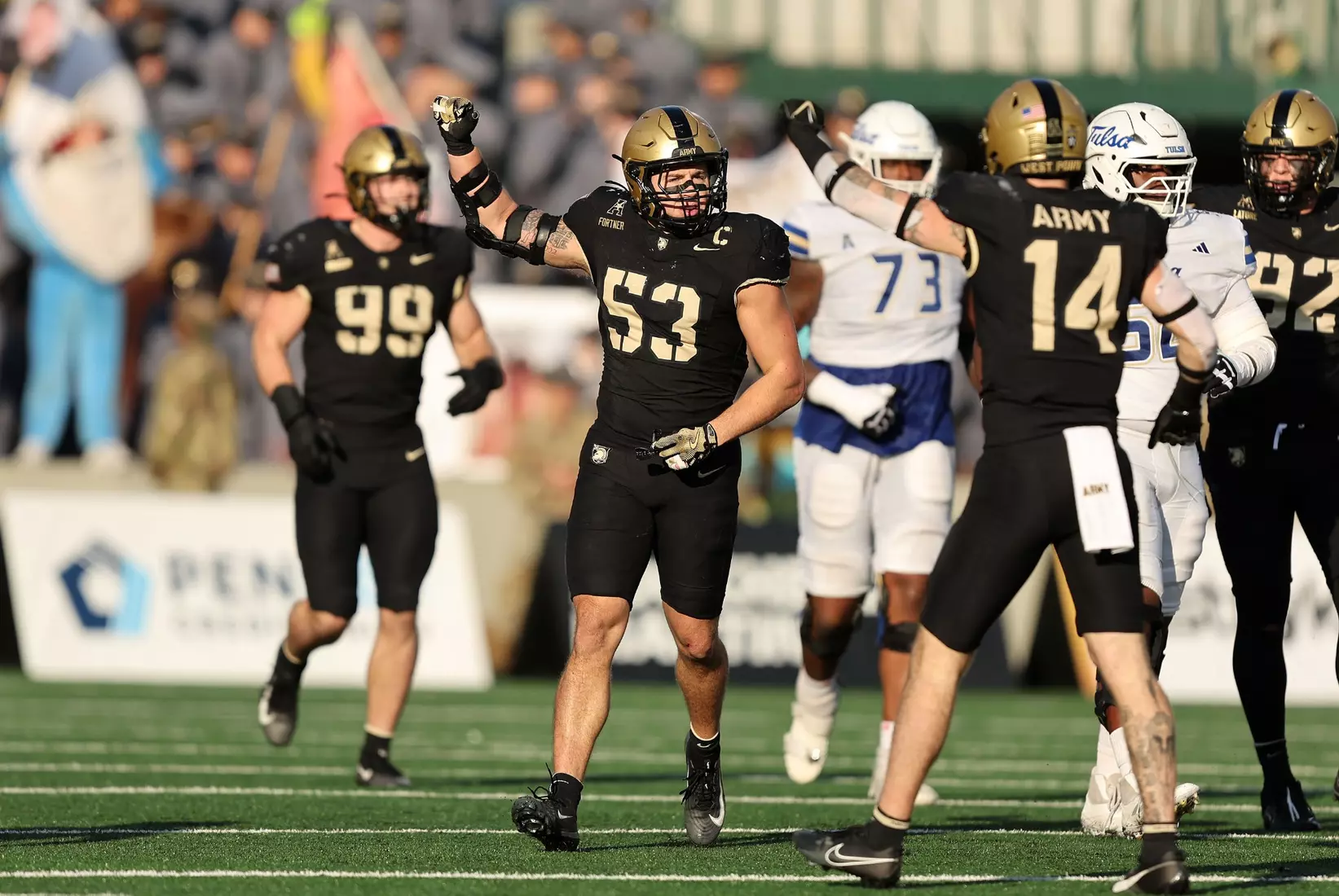 Army linebacker Kalib Fortner (#53) celebrates a defensive play on the field during a game, surrounded by teammates in black uniforms. Mandatory Credit: Danny Wild-Imagn Images/ Army Athletics